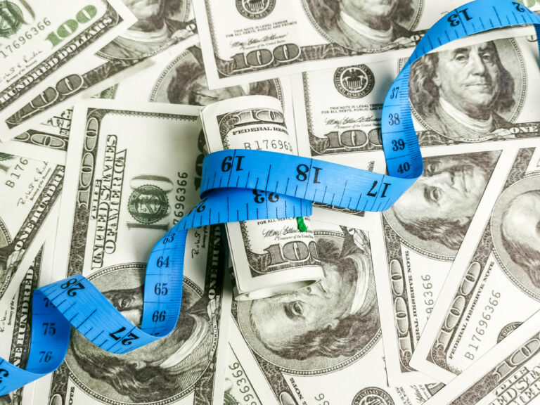 Dollar bank notes with measuring tape.