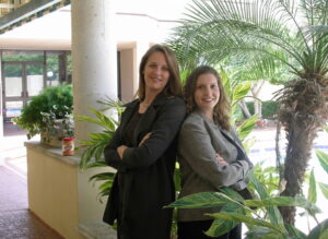 Diane Elkins and Desiree Pinder pose together with a jar of peanut butter on the ledge behind them.